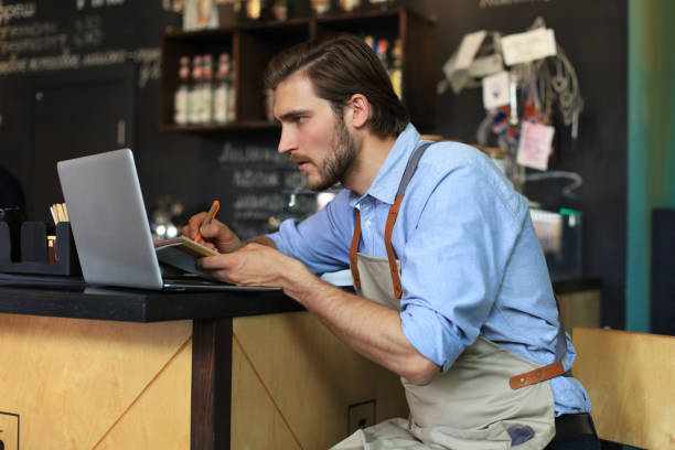 istock Restaurant manager working on laptop, counting profit. 1252915613