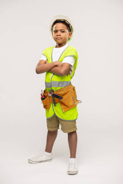 istock Serious boy of elementary age wearing uniform jacket, toolbelt and hardhat 1252918969