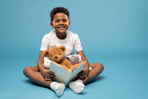 istock Joyful boy of elementary age looking at you with toothy smile while reading 1252919019