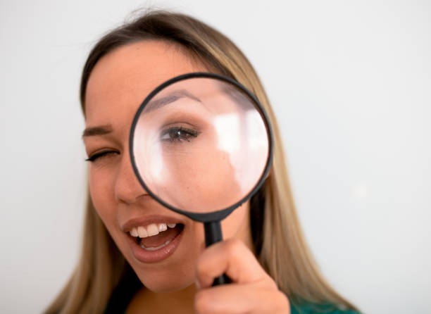 istock Young attractive woman looking through magnifying glass 1252922230