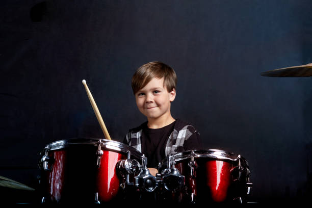 istock A brunette child boy plays the drums. Studying in the studio. 1252926246