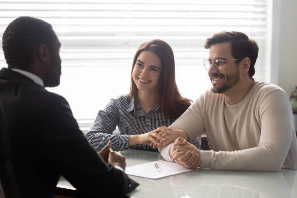 istock Couple and insurance agent communicating sitting at desk 1252926457