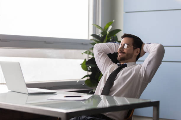 istock Businessman put hands behind head enjoy day off at workplace 1252926512