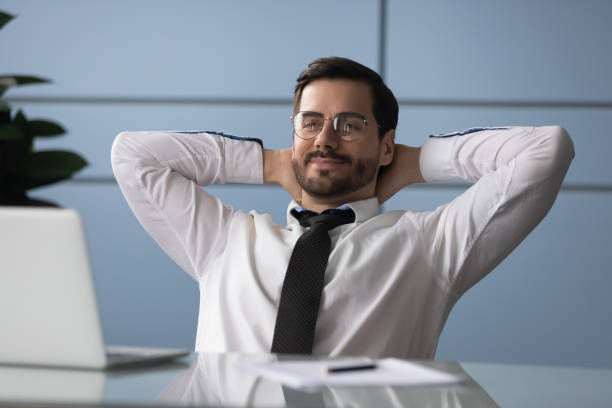 istock Businessman put hands behind head resting enjoy break at workplace 1252926514