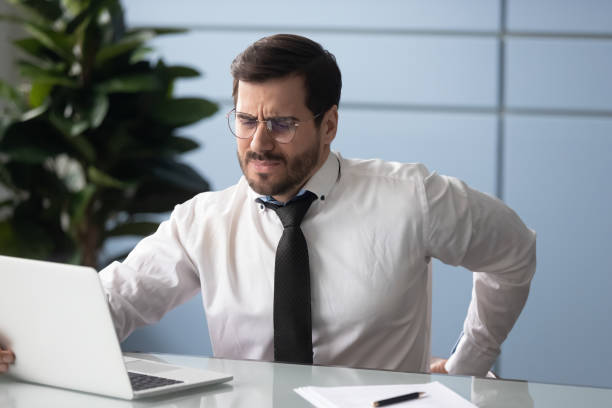istock Businessman rubbing aching back feels unhealthy, sedentary work concept 1252926524