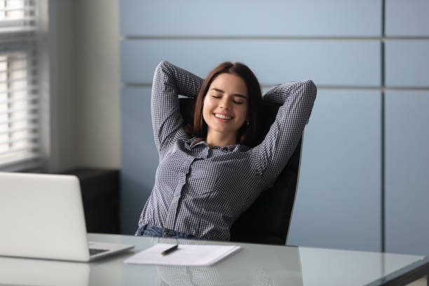 istock Woman sitting put hands behind head enjoy repose during workday 1252926563