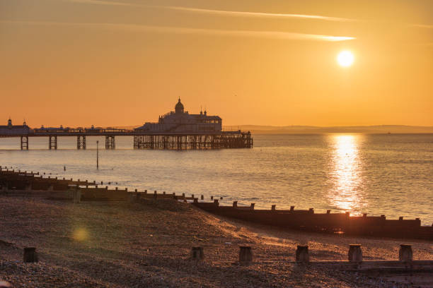 beau lever de soleil au-dessus de l’horizon de manche et de jetée d’eastbourne, east sussex, royaume-uni - horizon over water england uk summer photos et images de collection