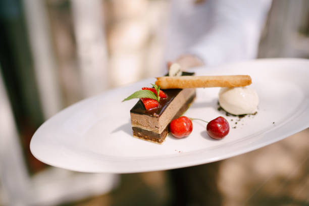 istock Choclate mouse cake decorated with dark chocolate ganache, mint and strawberries with a side of vanilla icecream and cherries 1252946182