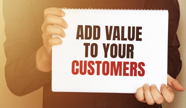 istock Businessman putting a card with text ADD VALUE TO YOUR CUSTOMERS 1252948240