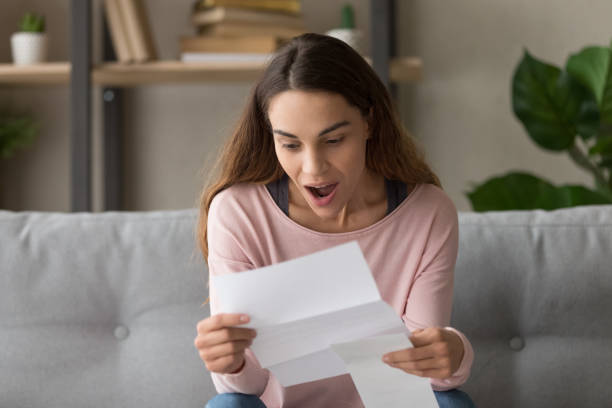 istock Surprised young female student holding paper document, perfect test results. 1252949344