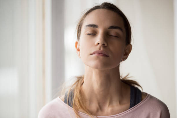 istock Calm young woman sitting with closed eyes. 1252949382