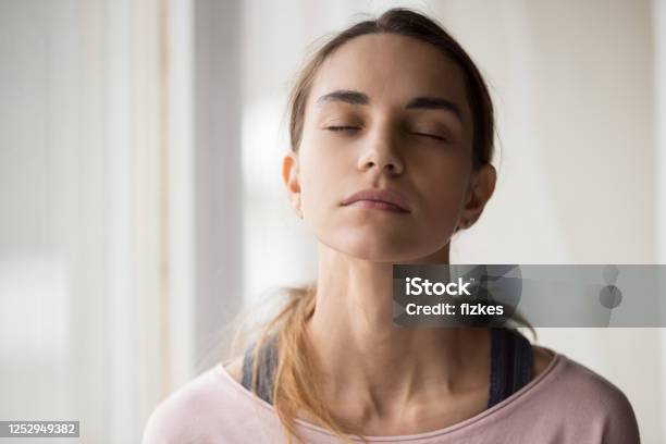 Calm Young Woman Sitting With Closed Eyes Stock Photo - Download Image Now - Meditating, One Woman Only, Women