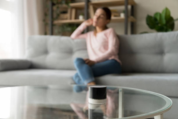istock Focused modern wireless speaker with blurred young woman on background. 1252949399