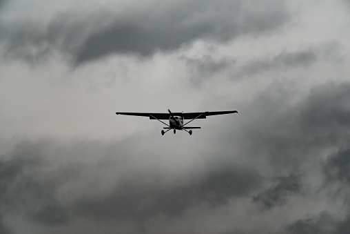 A small light prop aircraft approaching a runway on a stormy day.  Newtownards, County Down, Northern ireland.