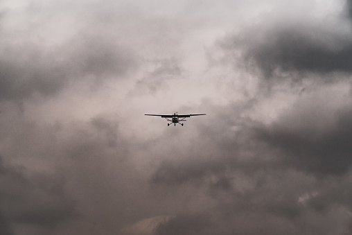 A small light prop aircraft approaching a runway on a stormy day.  Newtownards, County Down, Northern ireland.