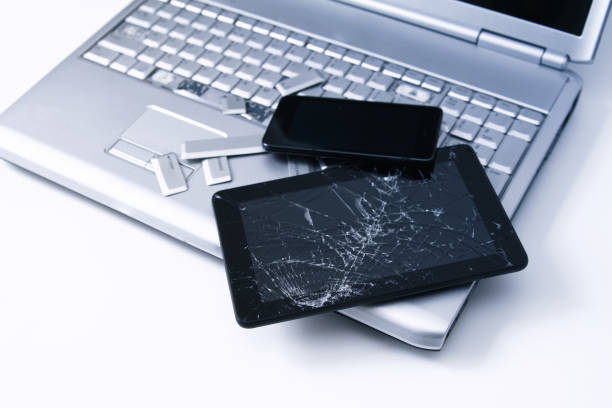 istock A silver laptop with a broken keyboard, tablet with a cracked display and black phone. A close-up picture of part of broken laptop and cracked screen on a tablet. 1252952390