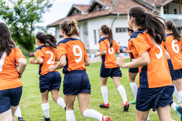 istock Female soccer players jogging for warming up 1252954972