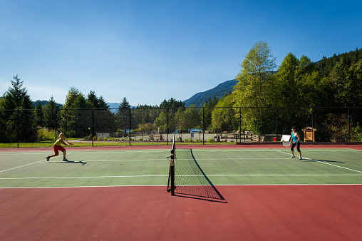 Women staying active through sport. Friends playing tennis. Outdoor recreation.
