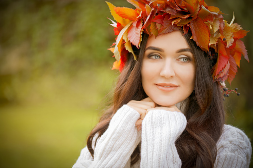 young beautiful woman with a wreath on her head, outdoors