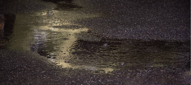 istock twilight puddle on the asphalt rain reflection of light in the waves 1252963707