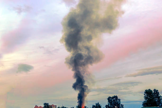 the building burns with fire and black smoke against the evening sky.