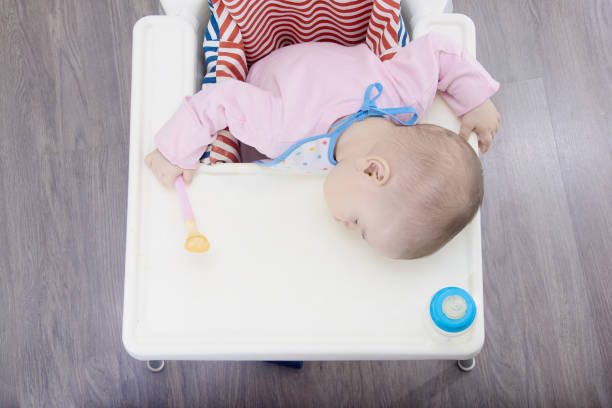 istock baby sleeping while eating in a chair 1252968751
