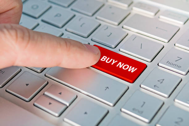 istock Computer notebook keyboard with Buy key - technology background, Buy now inscriptions on the grey silver keyboard button close up 1252975344