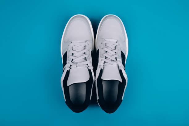 istock Stylish gray sneakers on a blue background. 1252975495