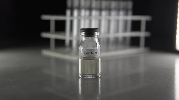 istock Glasses and light bulbs with covid 19 vaccine 1252976864