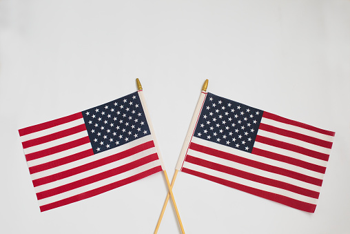 Two American flags crossing each other isolated on white background
