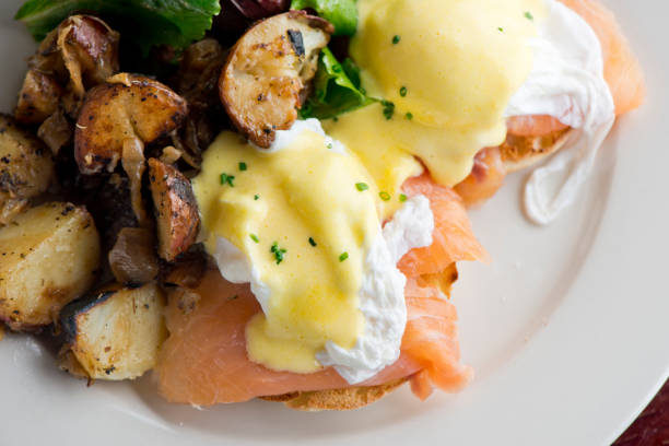 istock Eggs Benedict. Poached eggs w/ potato hash served in a cast iron skillet. English muffin. eggs, country ham, melted cheese, & homemade hollandaise sauce. Classic French or American cuisine favorite. 1252991463