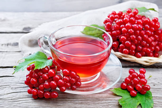istock Tea from viburnum in cup on old wooden board 1253002539