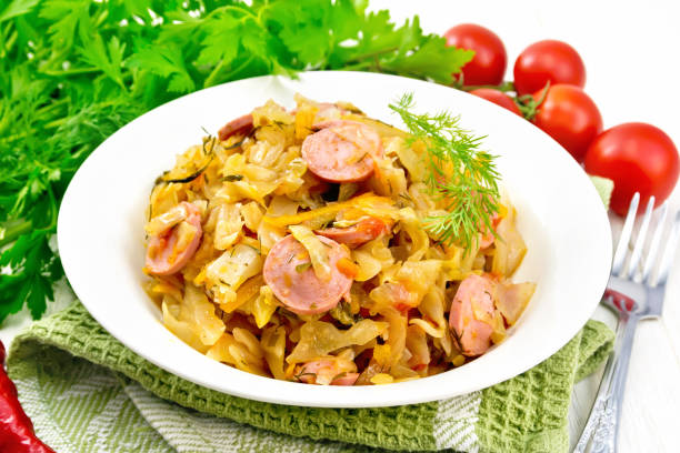 istock Cabbage stew with sausages in white plate on board 1253004741