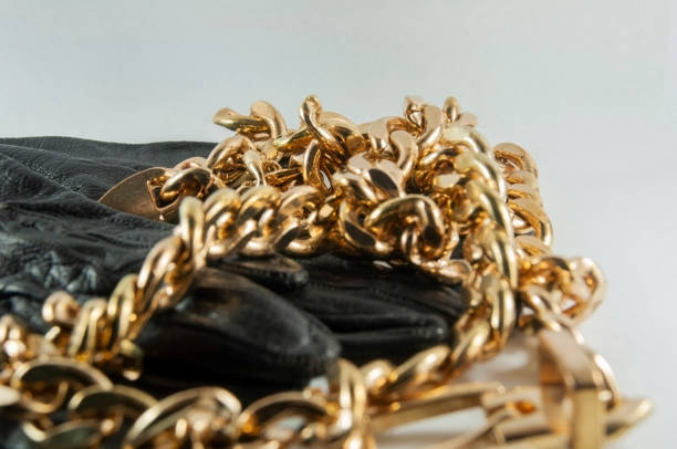 istock Black gloves and gold chain 1253005762