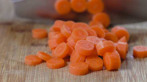 hacher la carotte sur une planche à découper en bois, fermez-vous - carrot close up silverware cutting board photos et images de collection