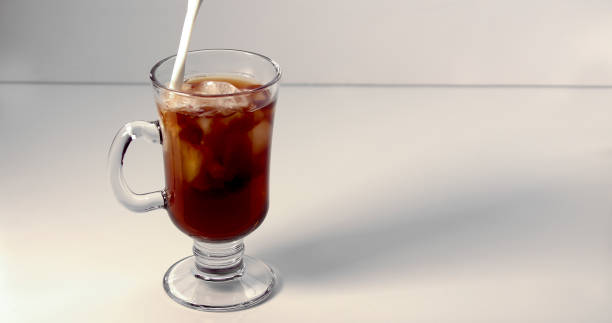istock Pouring cream on an ice coffee cup on a white background 1253007539