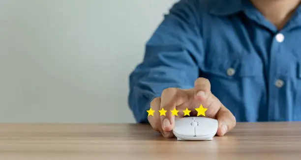 Photo of Young man hand feedback rating gold five star icon