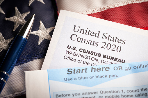 Censo 2020: formulario de cuestionario de encuesta en el escritorio con pluma y bandera de nosotros photo