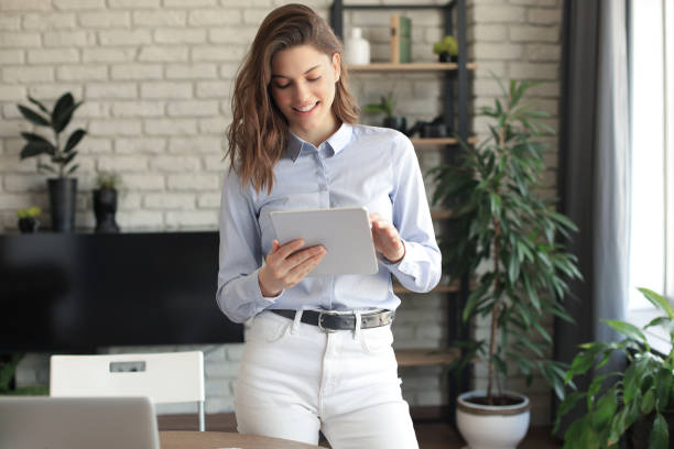 istock Attractive smiling woman working on a tablet in a home office. 1253011861