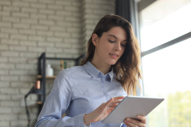 istock Attractive woman working on a tablet in a home office. 1253012751