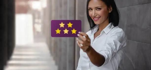 Photo of Customer Experiences Concept. Happy Young Business Woman Giving Five Stars Rating and Positive Review on Card. Client's Satisfaction Surveys. Front View