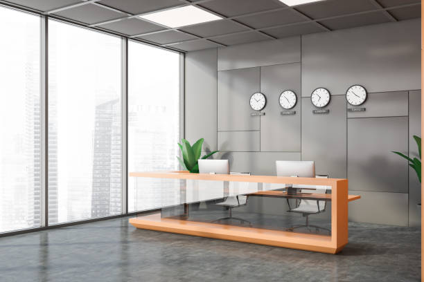 istock Gray and orange office corner clocks and reception 1253019889