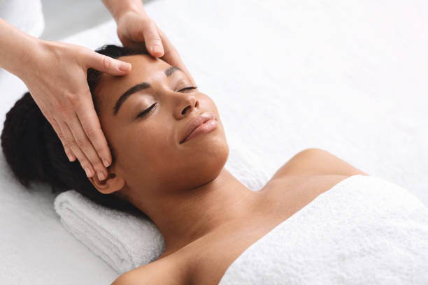 istock Black lady having relaxing head massage at spa salon 1253026474