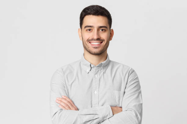 uomo d'affari sorridente in camicia grigia isolata sullo sfondo dello studio - crossing human arm leadership men foto e immagini stock