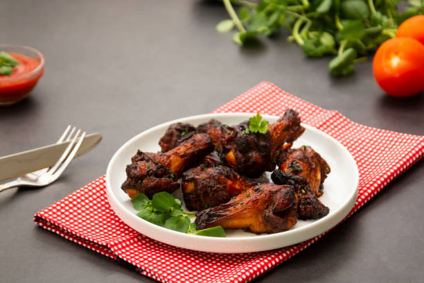 istock Roasted chicken legs, drumsticks on plate with fresh vegetables. 1253036933