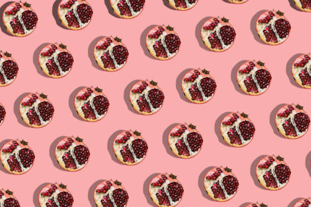 istock Red garnet on a pink background. Fashion seamless models. Fruit template 1253036956