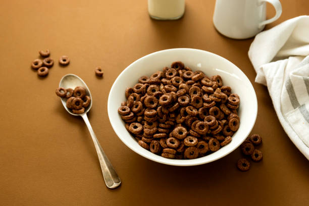 istock Chocolate cereal rings in bowl brown background. Breakfast for kind. 1253036973
