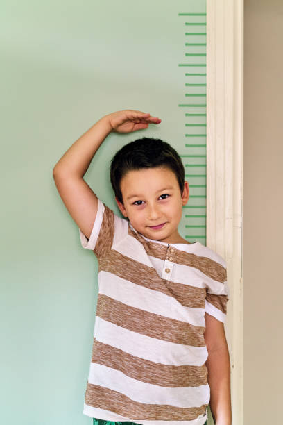 istock Child measuring his height on wall. He is growing up so fast. 1253039988