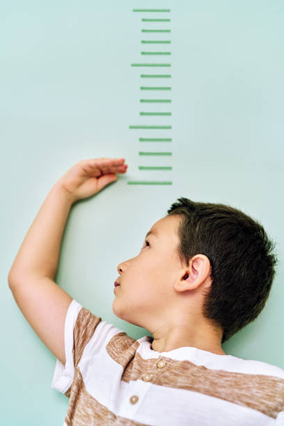 istock Child measuring his height on wall. He is growing up so fast. 1253040013
