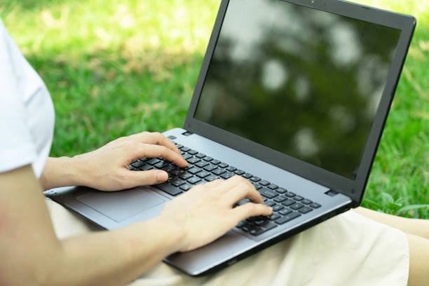 istock Selective focus,Working on laptop outdoors.Woman sitting on grass at park,relaxing  while under a tree.Nature essential wellbeing and ability be productive. 1253040059